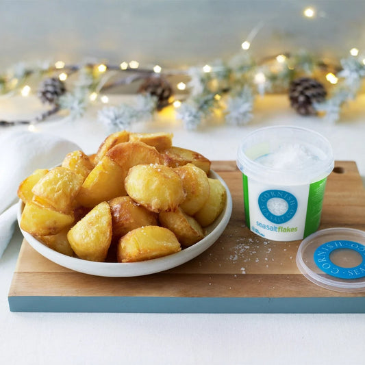 Roast potatoes with Cornish Sea Salt Flakes being sprinkled on top